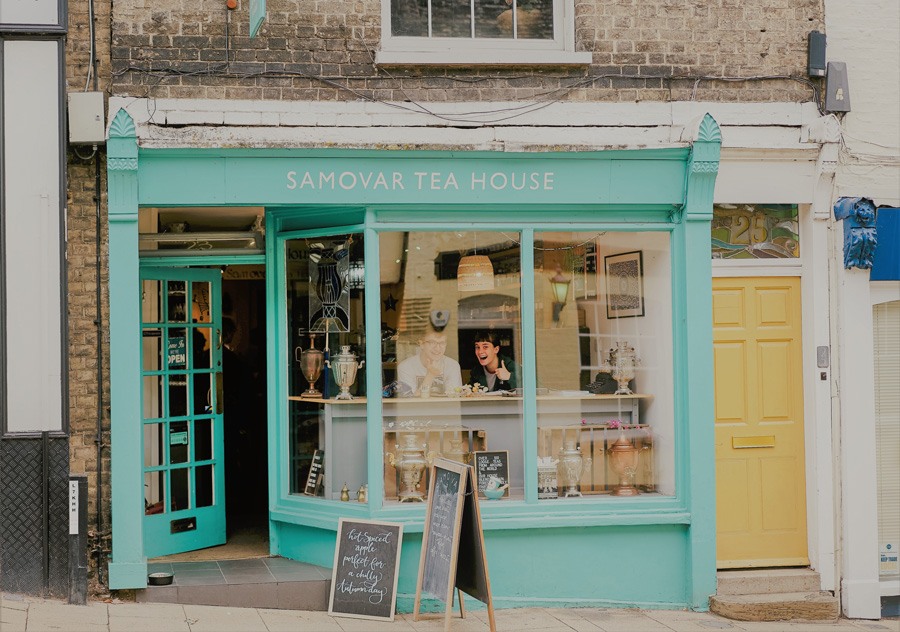 tienda calle tienda de te con una pareja sonriendo en su interior
